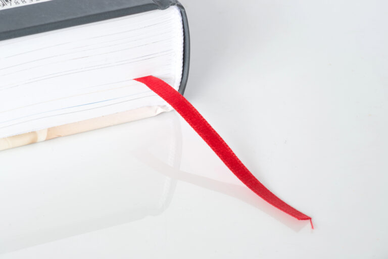 Closed book with red ribbon bookmark